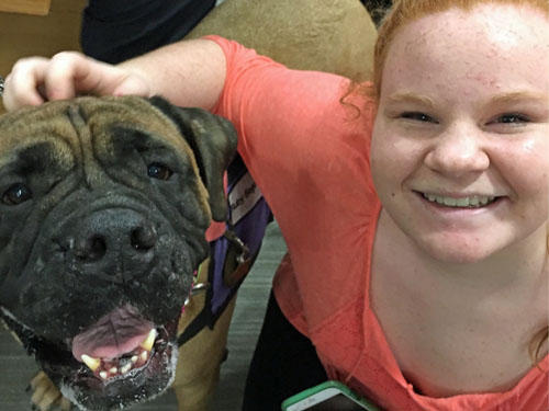 Therapy dog Ruby Begonia (retired) poses for a snapshot with a child