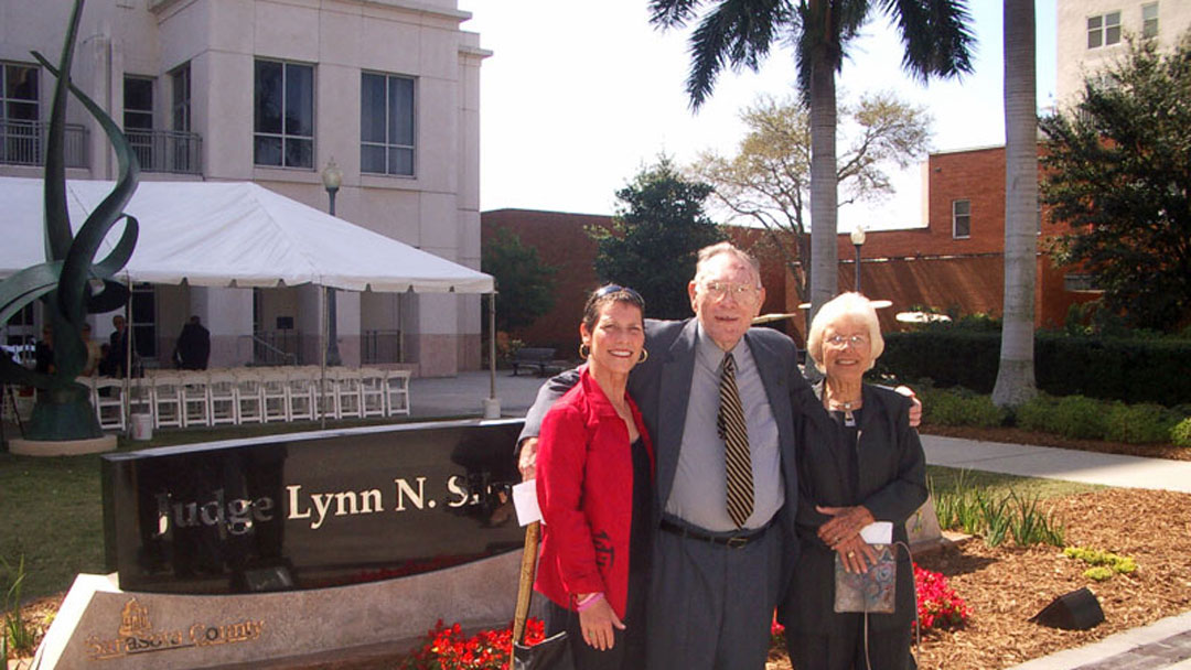 This is an image of one man and two women standing in front of a sign that says Judge Lynn N. Silvertooth Judicial Center.